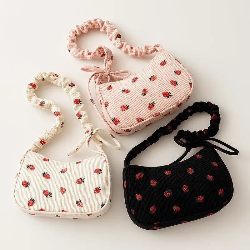Lot de trois mini sacs bandoulière en velours côtelé (blanc, rose, noir) à motifs fraises.