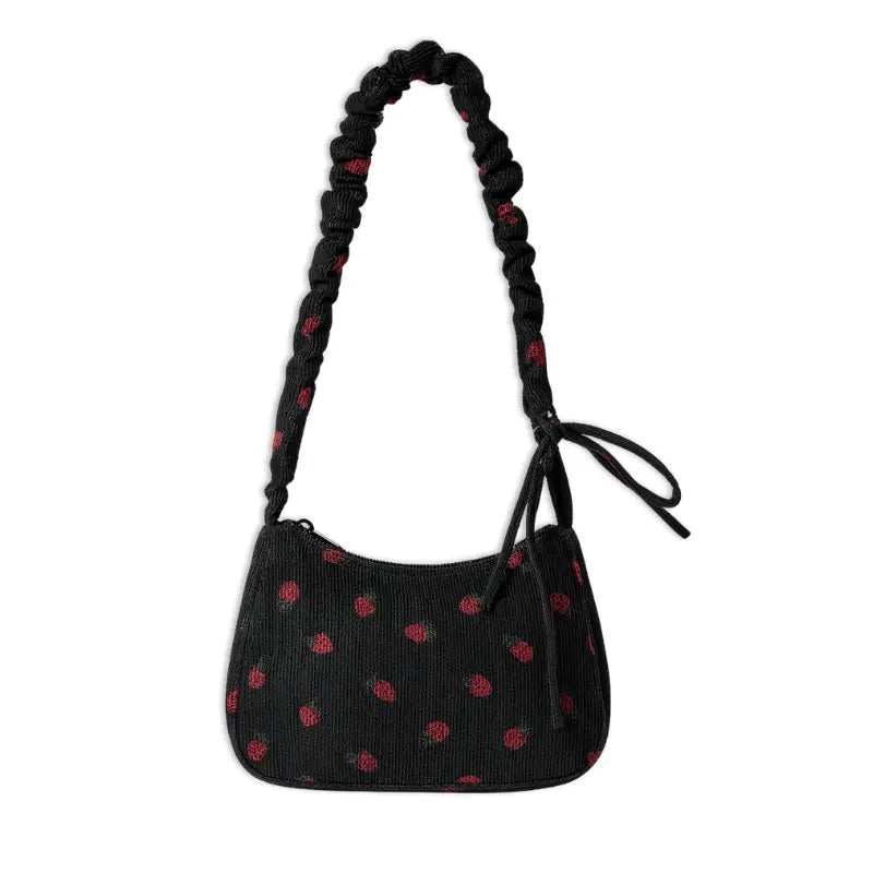 Mini sac bandoulière en velours côtelé noir décoré de motifs fraises rouges.