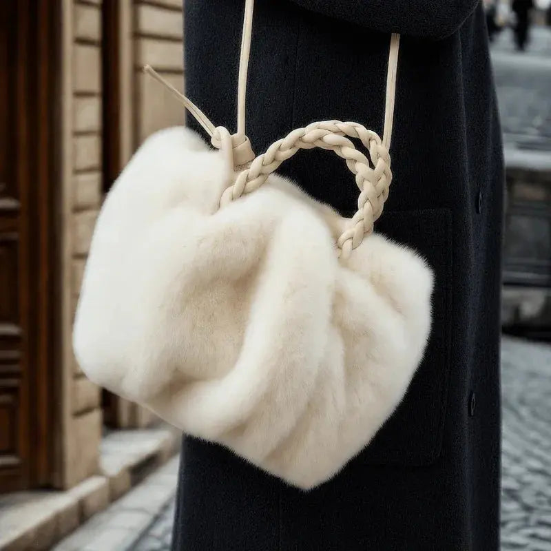Sac à main en fausse fourrure porté avec manteau noir.