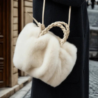 Sac à main en fausse fourrure porté avec manteau noir.